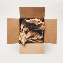 Cardboard box lined with packing paper, ready for toner cartridges